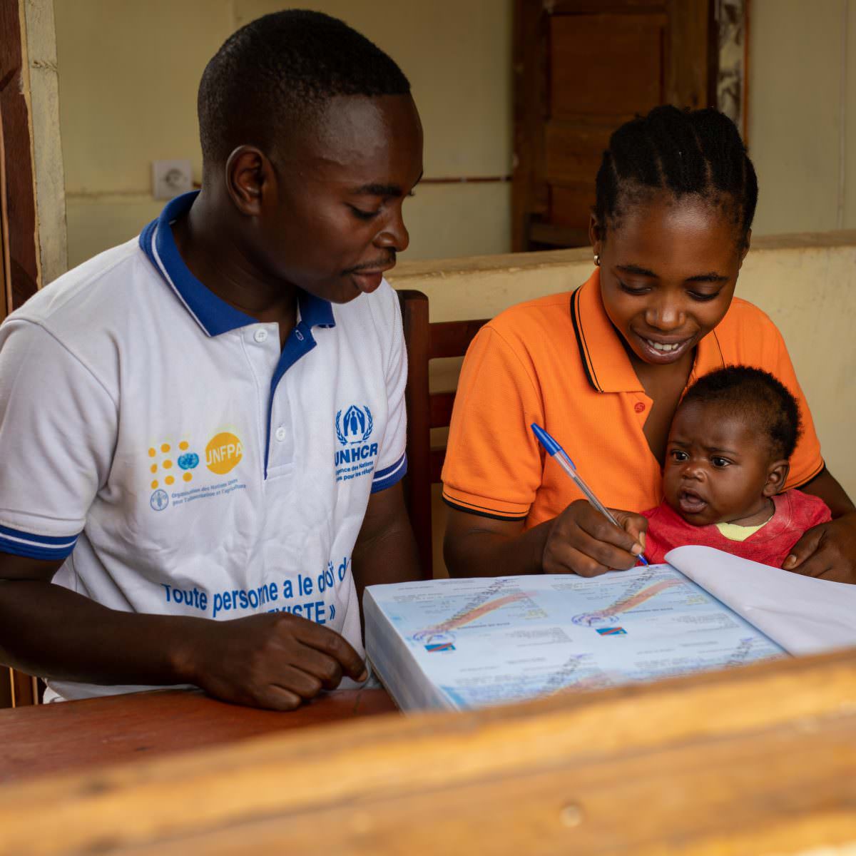 On November 13, 2021, Raphaël Yuse, Civil Registry officer, registers the birth of Léon Kabengele, 3 months old, in Tabac-Congo, a village situated 25km north of Kalémie, in the province of Tanganyika, east of the Democratic Republic of the Congo. ; In the Tanganyika province, it is estimated that only 35% of births are registered in the Civil Registry. The main reason is the distance from the Civil Status offices: on average, a person has to travel 120km to register the birth of a newborn. In the Democratic Republic of the Congo, parents have 90 days to register the birth of their child. After this deadline, only a supplementary judgment allows registration. As parents often do not have the financial means to pay for the legal procedure, the majority of children grow up without civil documents and are not recognized by the Congolese state. To promote an increase in the registration rate in remote localities and help reduce the risk of statelessness, UNHCR supports the Tanganyika authorities by providing means of transport, motorcycles and bicycles, and proxy books, called village notebook, which allows civil status officers to register births directly in the villages, thus preventing mothers from traveling.