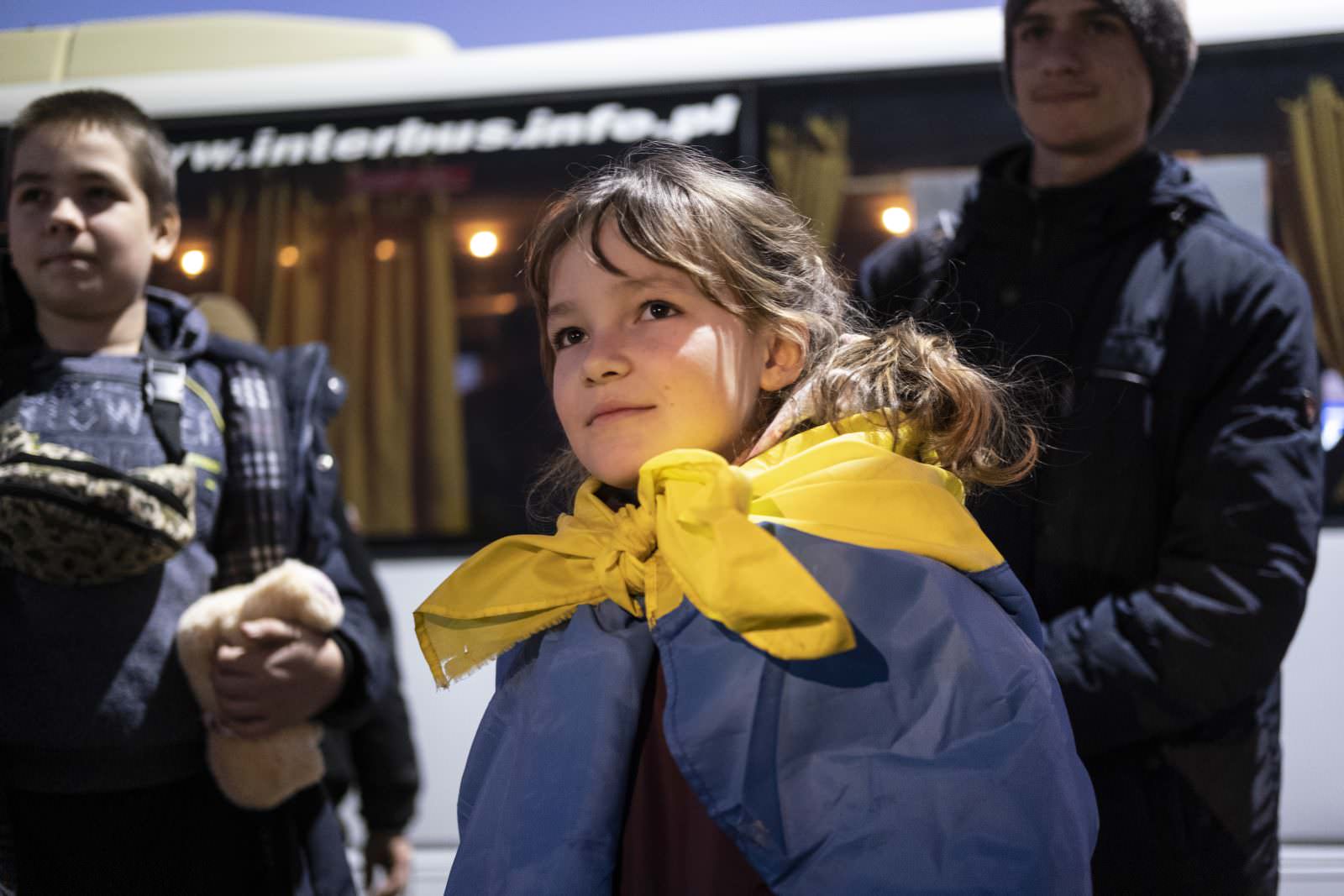 Eight-year-old Anastasia Kulchyckiy waits at the Medyka crossing point for a bus to the nearby town of Przemysl with her father Mykolay, 51, and her brothers Mihailo, 14, and Dmytriy, 17 after arriving from Ukraine. Medyka is the largest crossing point for refugees from Ukraine. Most need a place to pause, regroup and recover before moving on to other cities in Poland or beyond. ; By 21 March, more than 10 million people had been forced to flee their homes because of the war in Ukraine, many displaced inside the country and more than 3 million as refugees abroad. Within three weeks, arrivals in Poland passed the 2 million mark. UNHCR has been working with national authorities, local administrations, municipalities and civil society to cope with the influx.