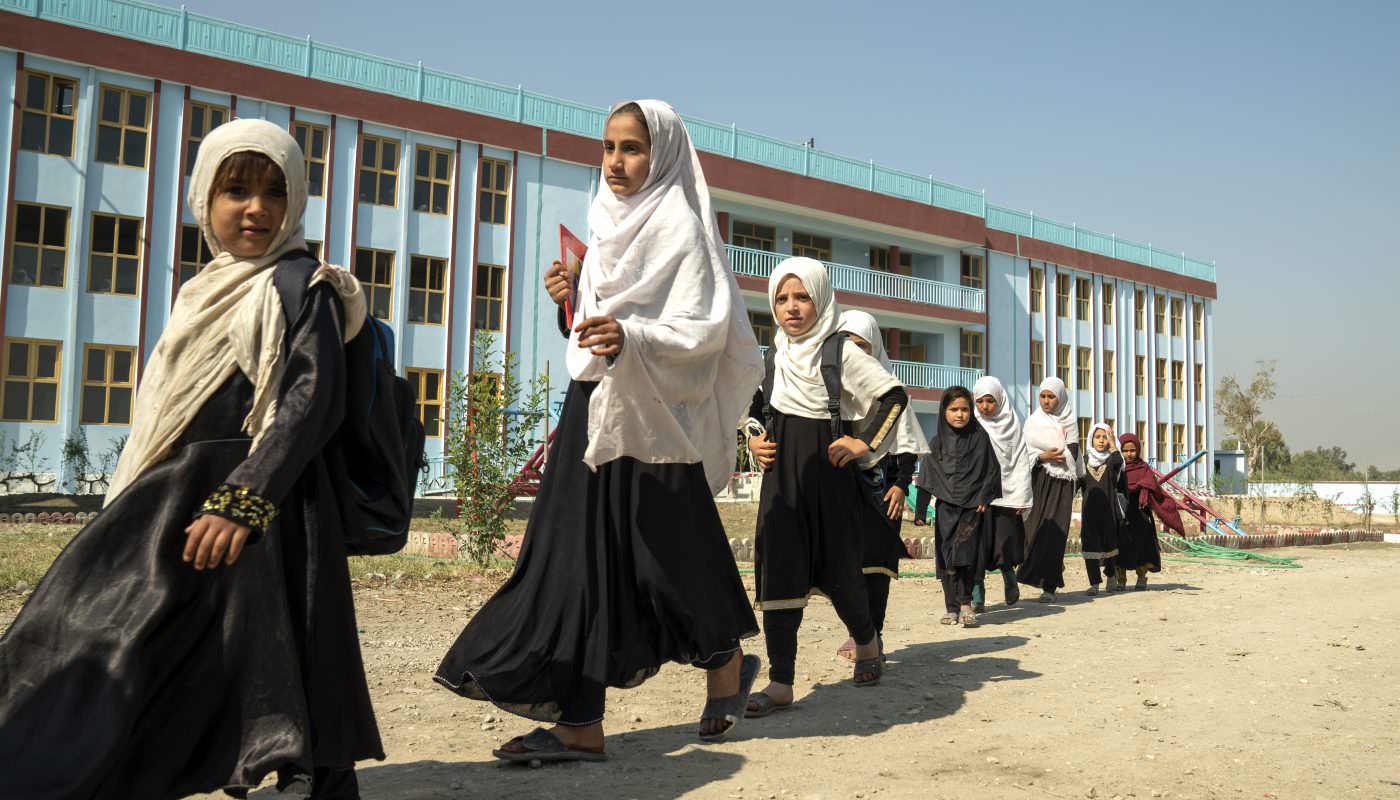 Female students leave school to go home after the morning session at Lower Sheikh Mesri high school in Jalalabad, Afghanistan. As girls above Year 6 cannot now go to school in Afghanistan, the premises are used for boys only from Year 7 and above in the afternoon. ; Director of External Relations Dominique Hyde visited Afghanistan during a mission to the country in November 2022. UNHCR is targeting support towards 80 Priority Areas of Return and Reintegration, which are home to more than 19 million people. These areas comprise the country’s five main cities, including Jalalabad, plus 75 districts. UNHCR is providing schools, health centres, water projects and roads, and supporting livelihoods projects to help make returns more durable and mitigate future displacements by ensuring localities are more resilient.